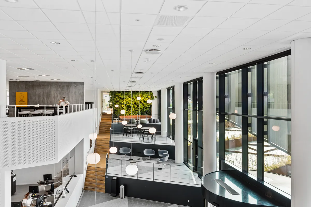 Kontorhuset med serviceret reception, fælles kantine og mødecenter. Moderne interiør med lyse lofter, hvide vægge og store vinduer