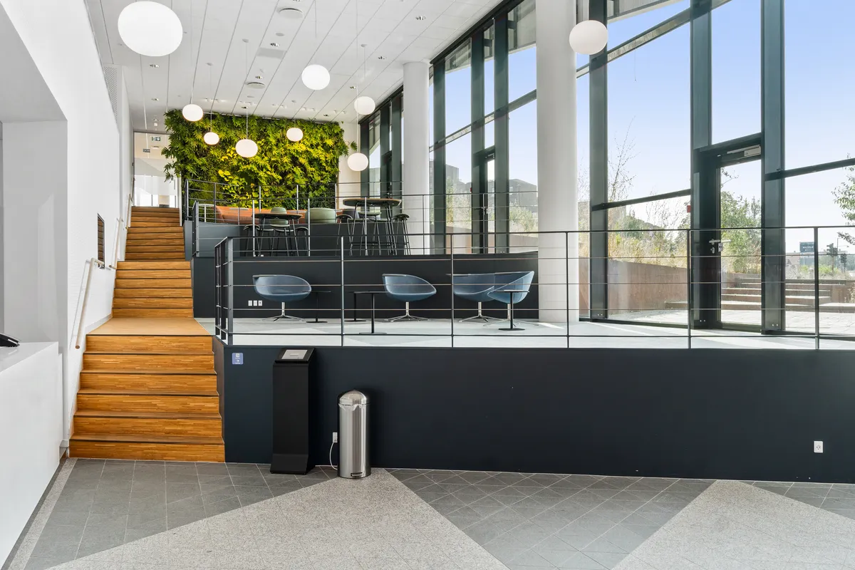 Kontorhus med fælles kantine og mødecenter på Tobaksvejen 2A. Her er 5. sal med moderne reception, møderum og naturlige fællesområder. Komfortabelt kontormiljø med massivt trætrapper og lyse vinduer.