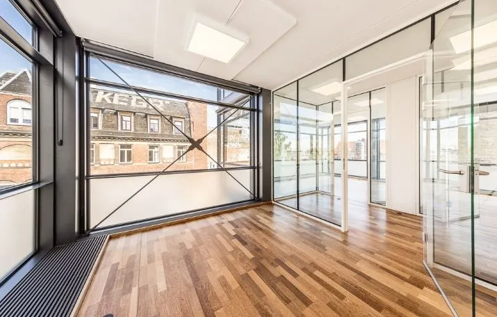 Kontor i miniskyskraber på Nørrebro med glasvinduer og hårdt trægulv samt udendørs gårdhave med solbelysning