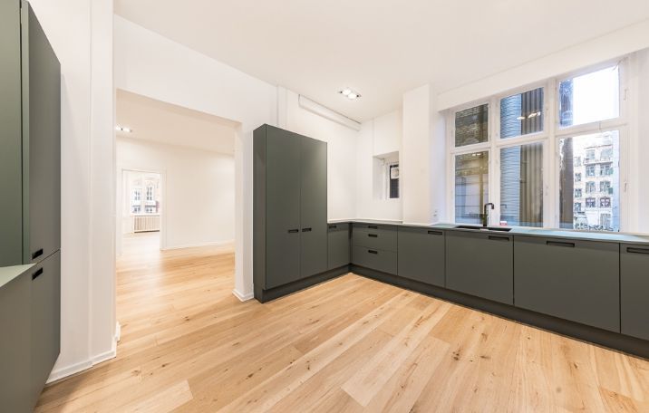 Klassisk kontor med moderne interiør og hjørnemødelokale. Slanke højhælede lofter, lyse gulve og vinduer med udsigt til byen.