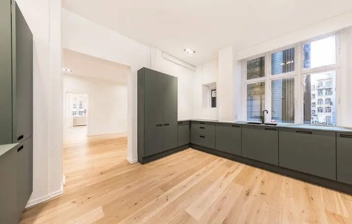 Klassisk kontor med moderne interiør og hjørnemødelokale. Slanke højhælede lofter, lyse gulve og vinduer med udsigt til byen.