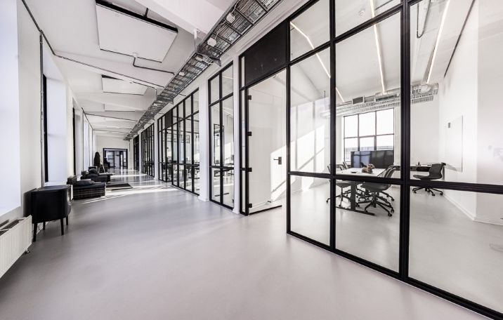 Moderne og minimalistisk kontor med hvide vægge, store glasruder og smukke udsigt over byen