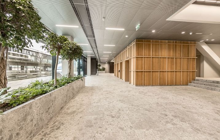 Kontor til leje på Kay Fiskers Plads 11 i København S. Minimalistisk indretning med træpaneler og grønne planter. Lys og rummelige lokaler med smukke gulvbelægninger og moderne interiørdesign.