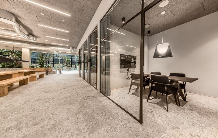 Kontor til leje i København med store glasvinduer, moderne møbler, lyse loftsbelægninger og naturligt lys fra gården.