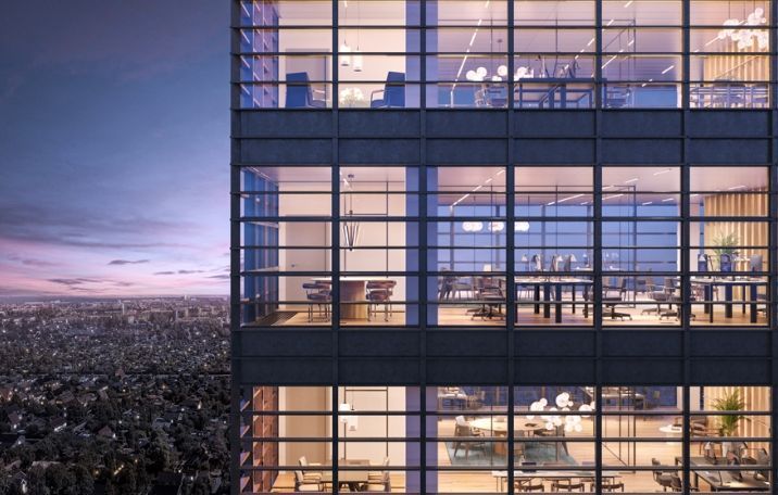 Lyserødt og blåt lys spredes gennem store glasvinduer i højhus med møbler og plante. Københavns skyline og træer i baggrunden.