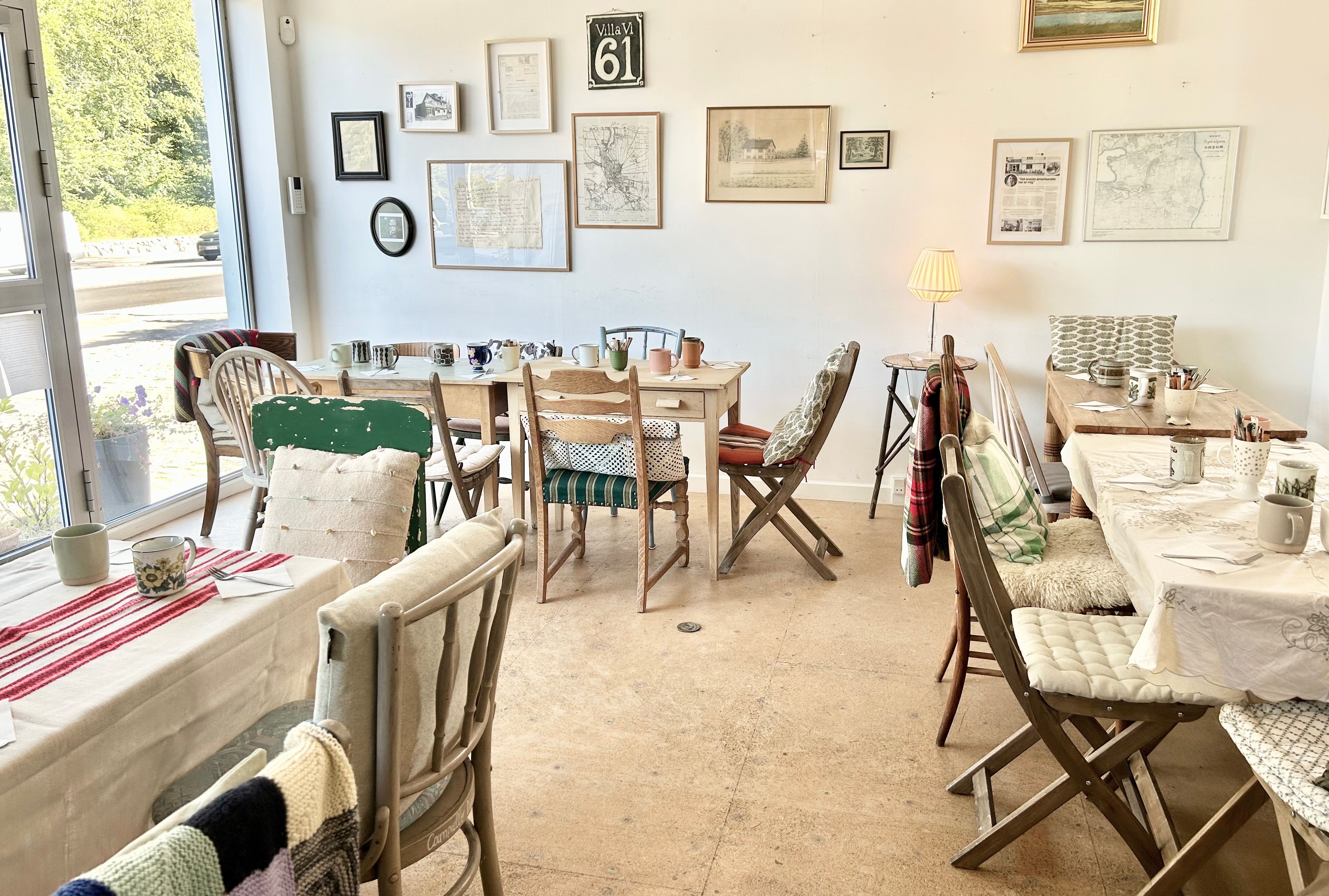 Lyst og charmerende værelse med lyse lofter og hyggelige møbler. En stor bord med stole og hyggeligt interiør. Væggene er prydet med hyggelige kunstværker og små genstande.