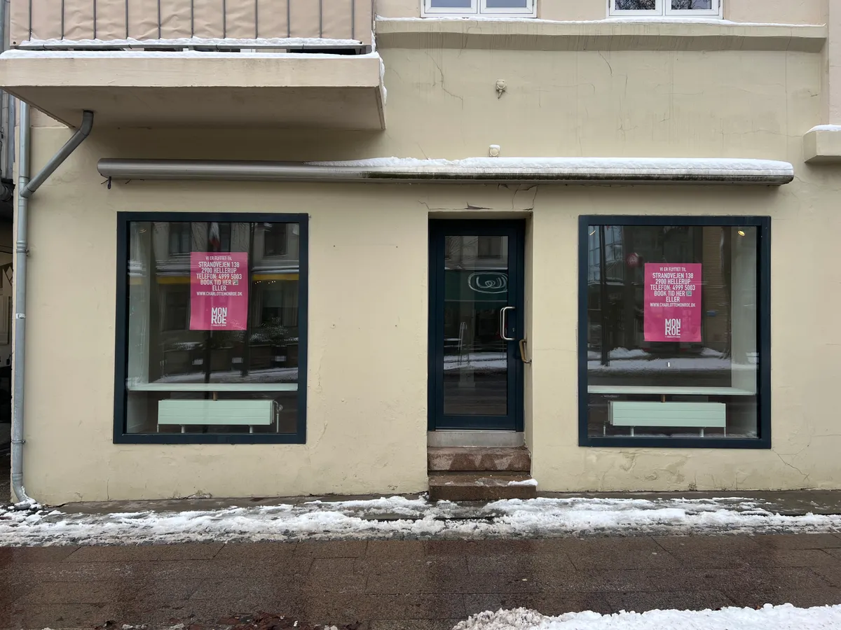 Butik til leje i Kongens Lyngby med røde skilte i vinduet og forruden dækket af sne og is. Adresse er Strandvejen 138