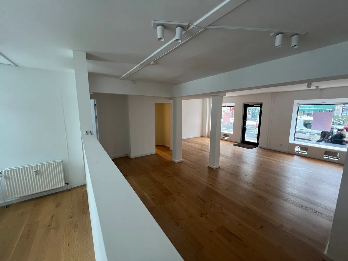 Store og lyse lokaler med højloft og trægulv. Store vinduer mod gaden og høj gulvdekning. Lokalerne er rummelige og er indrettet til detailhandel.