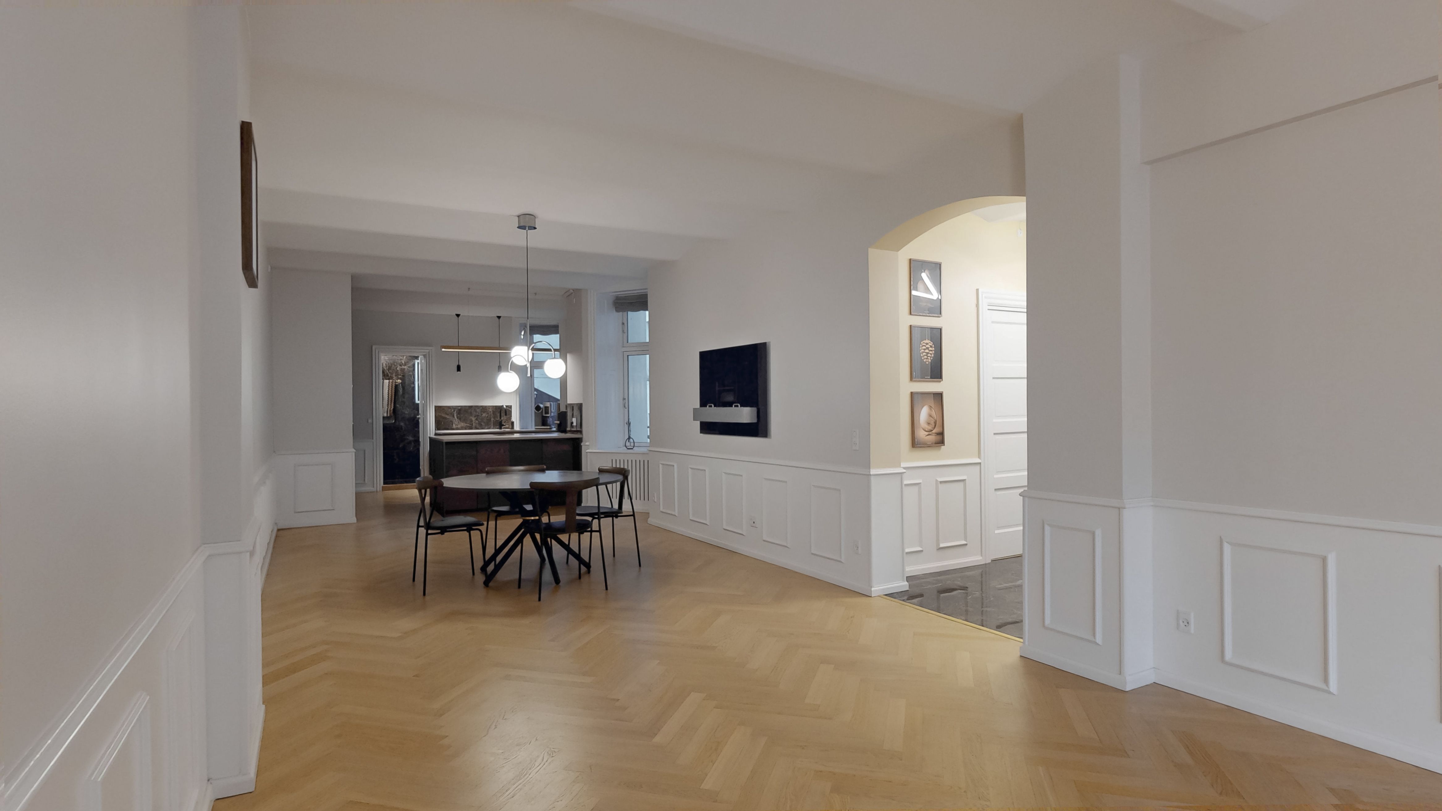 Indvendigt lyst og ryddeligt erhvervslokal med højt til loftet, lyse gulve og hvide vægge samt moderne møbler og teknologi