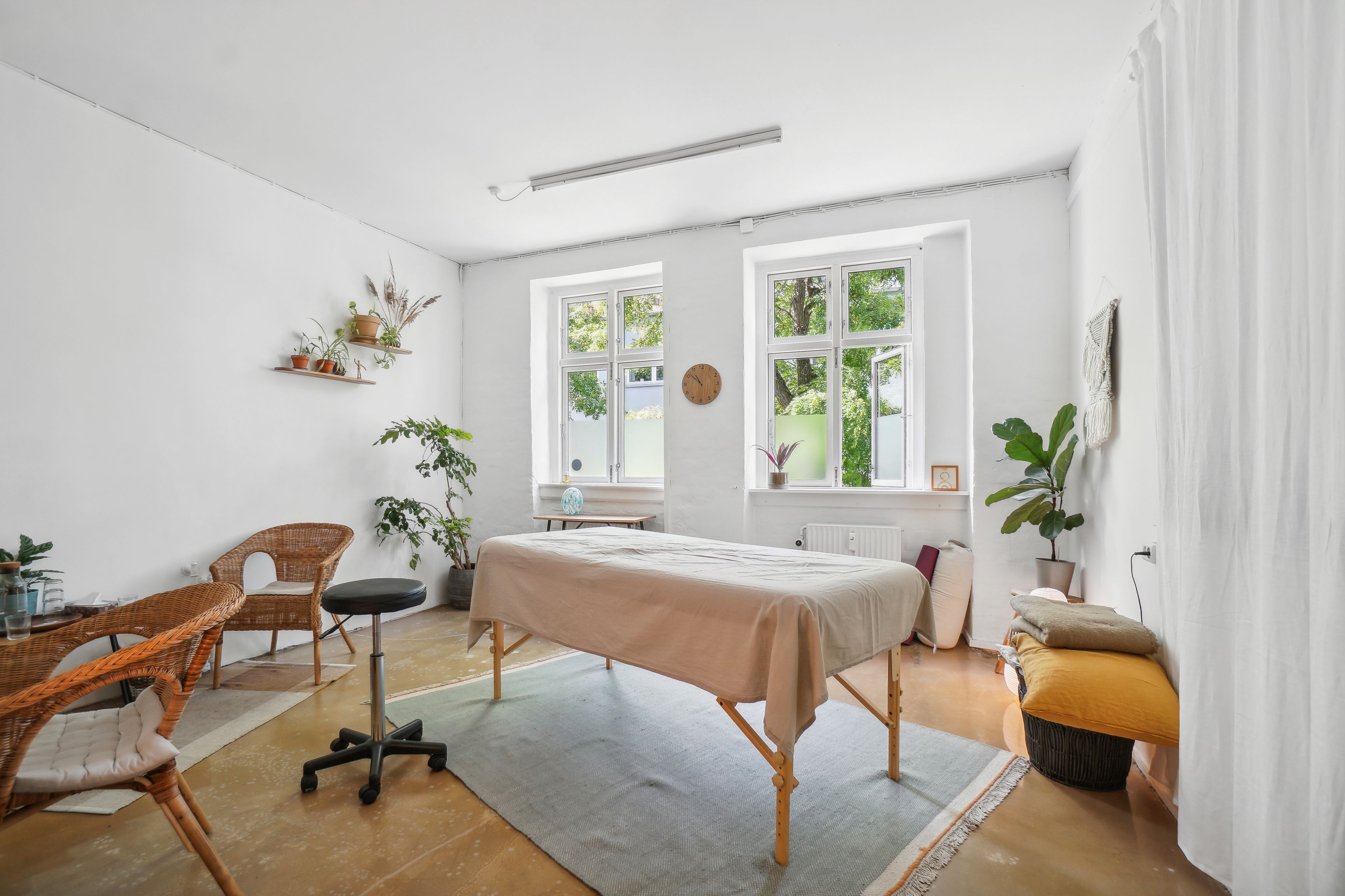 Råt og charmerende erhvervsmiljø med massagebord og træstole. Velegnet til studie, showroom, event eller kontor i Njalsgade-kvarter. Planter og møbler skaber et hyggeligt arbejdsmiljø.