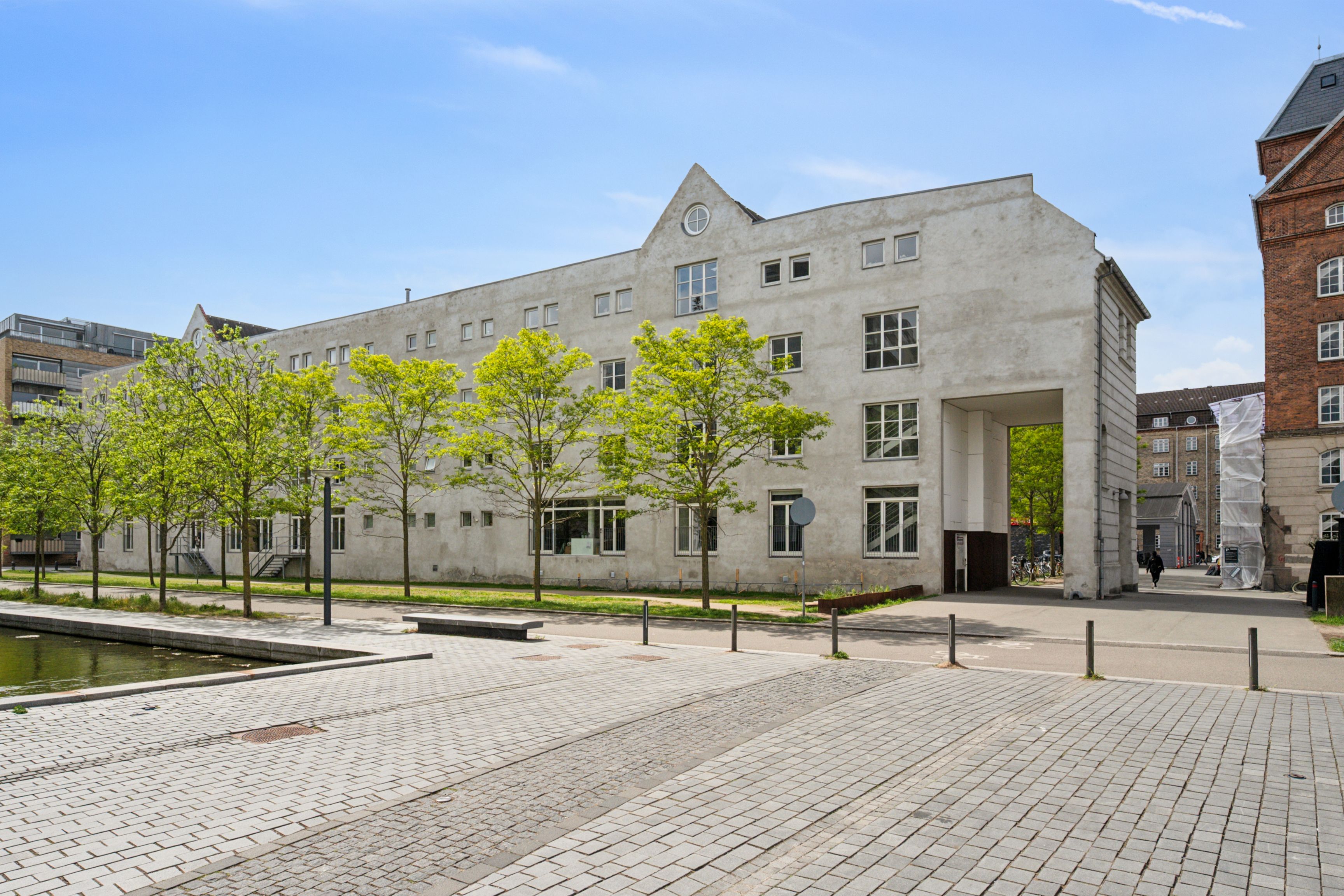Kontorbyggeri med industriel stil på Njalsgade 23C i København S med moderne træer og arkitektoniske detaljer som klokkekure