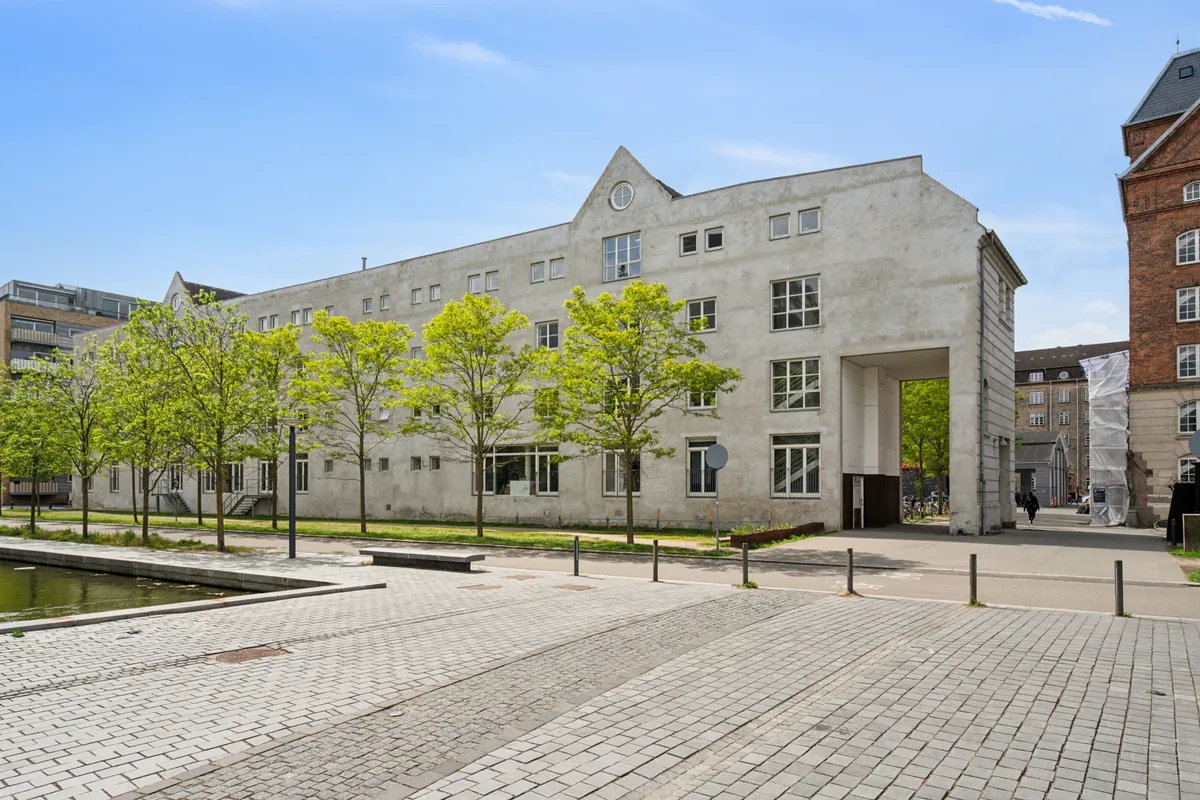 Kontorbyggeri med industriel stil på Njalsgade 23C i København S med moderne træer og arkitektoniske detaljer som klokkekure