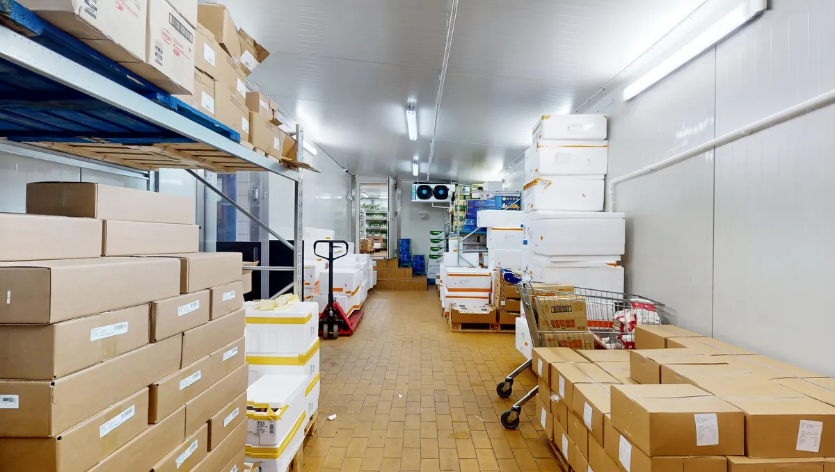 Lager med mange kartoner og bokse, hvoraf nogle er krydslagte og andre er sammenpakkede. Der er også en kørekurv og en stk. ventileret loft.