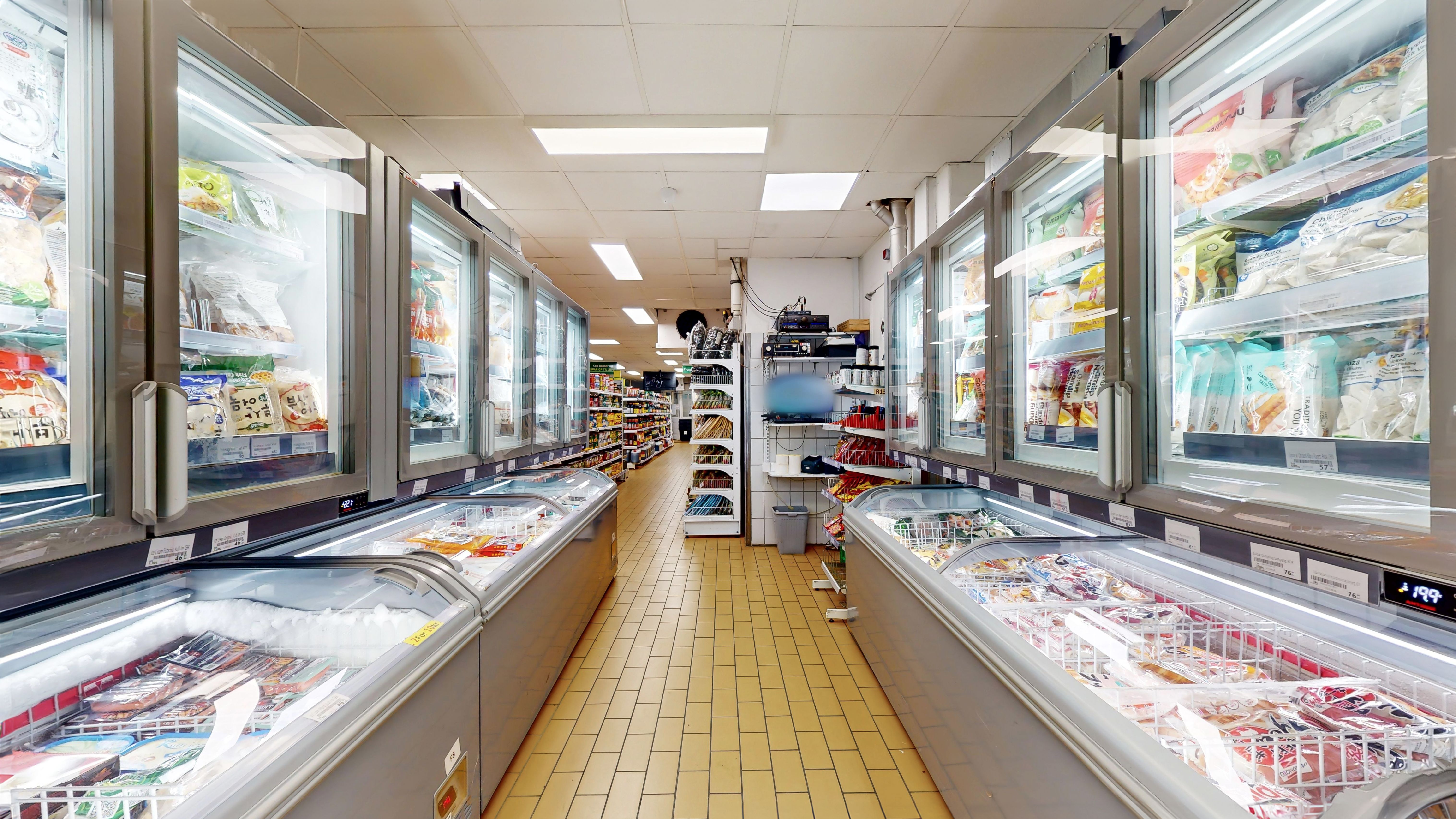 Kølekabinetter og frysere med forskellige varer og produkter. Store køleskabe med produkter og varer i isen. En række køleskabe med is og varer.