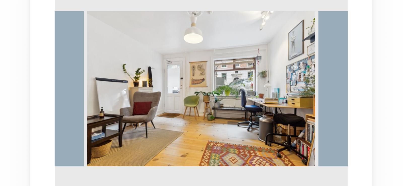 Et moderne og rummeligt kontor med lyse lofter og vinduer. Bord med stol og skrivebord samt en stol og skrivebord med flere bøger og plante