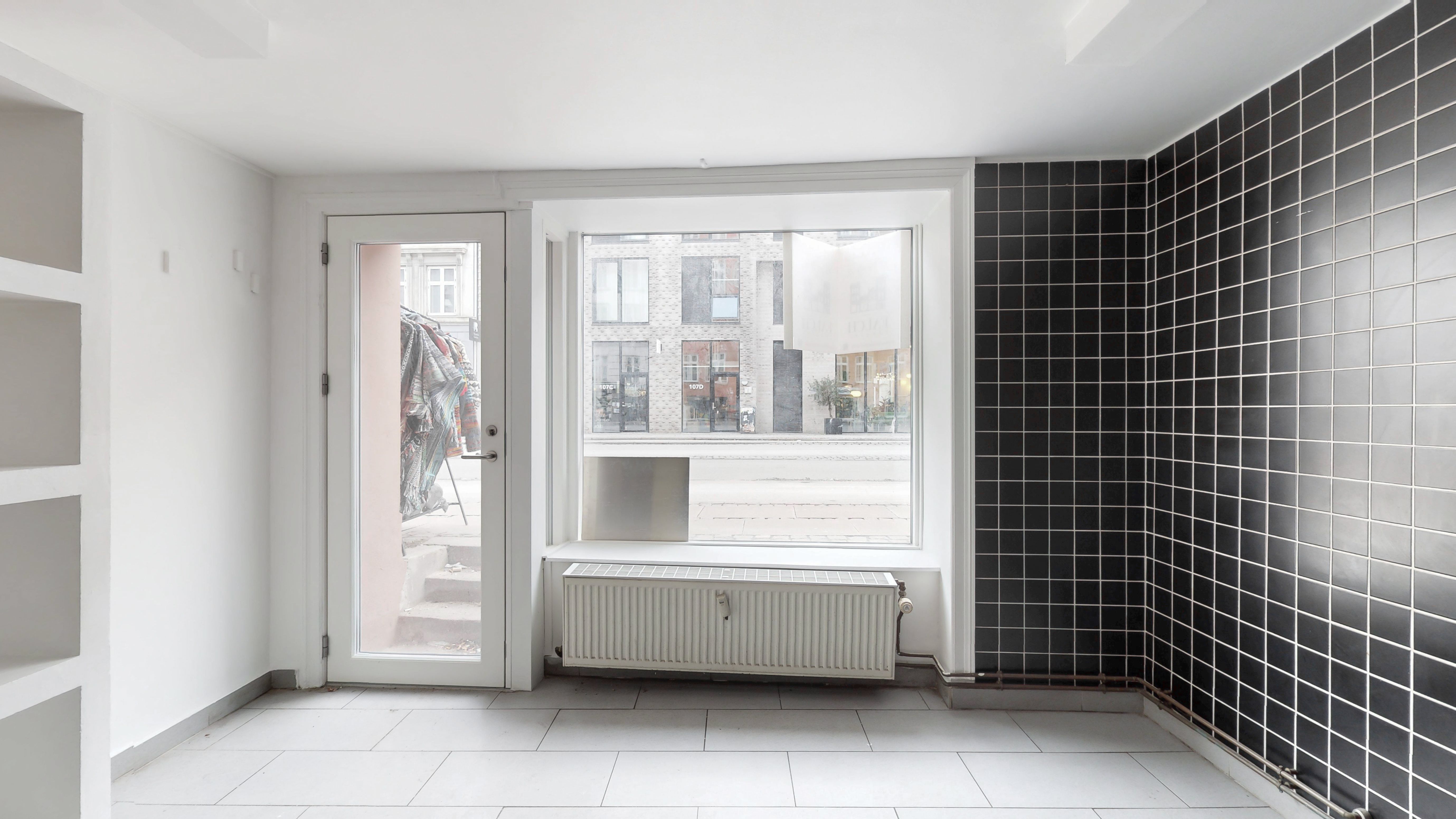 København V, erhvervslejemål, 51 m², hvidt interiør, gulv, radiator, sort og hvidt tøj, udsigt til Vesterbrogade, bygning, solskinsrefleks