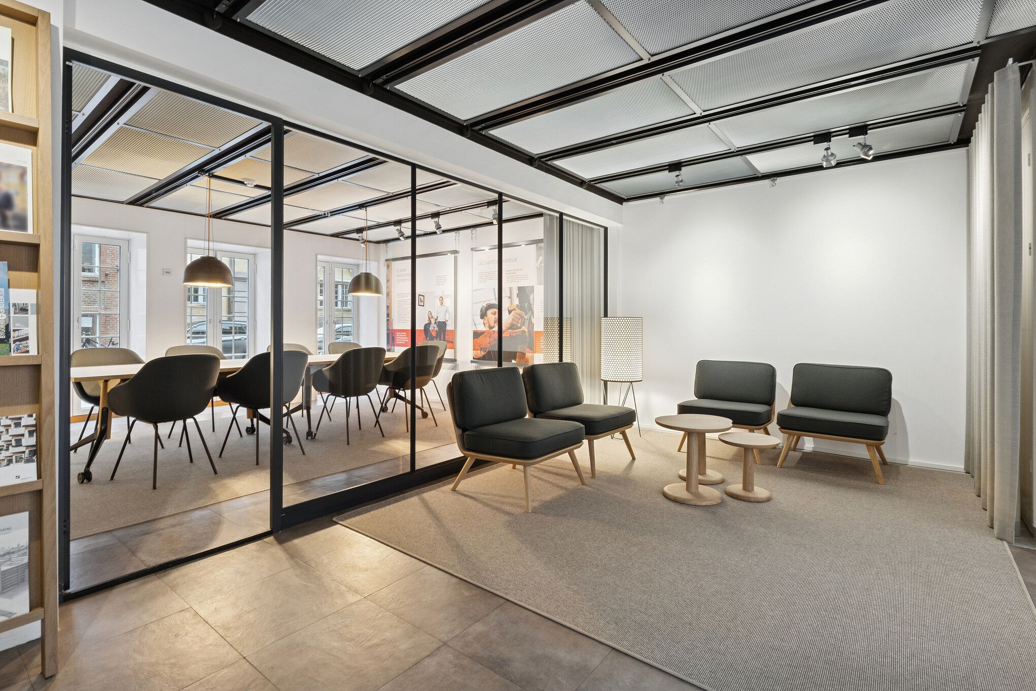 Kontorområde med moderne møbler og store vinduer i lyse farver og lysekroner og moderne lofter i en nyrenoveret bygning i historisk kvarter