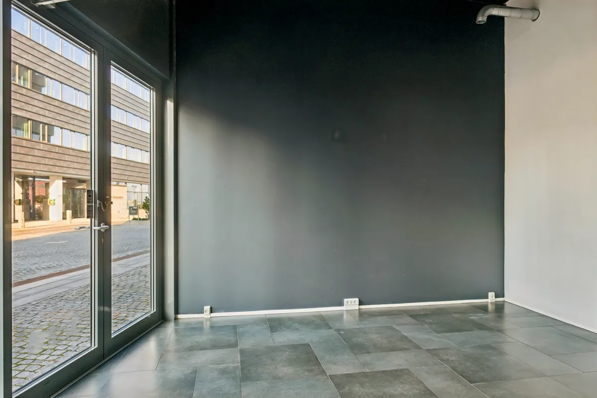 En stor lejlighed med moderne design, glasdøre, og en simpel, men elegant indretning tilbyder et nyt showroom eller butik.