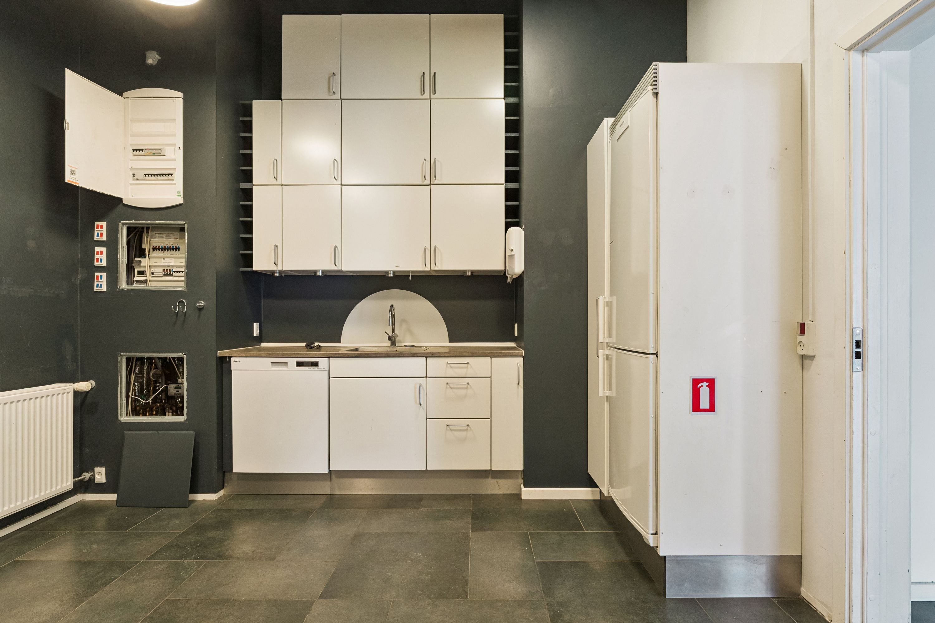 Butik til leje på Amerika Plads 34, st., 2100 København Ø. Nyd det indbydende køkken med hvide skabe og en hvid køleskab ved siden af