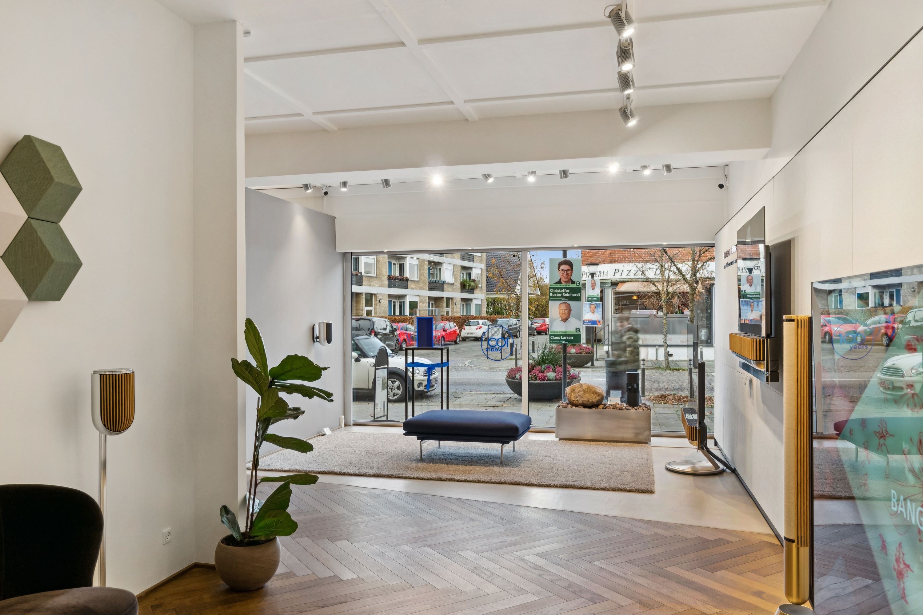 Investeringsmulighed i Vedbæk med moderne interiør, højt beløb, lyse loftslamper og udsigt til gårdhave med plantager og udsigt til gade med biler og bygninger.