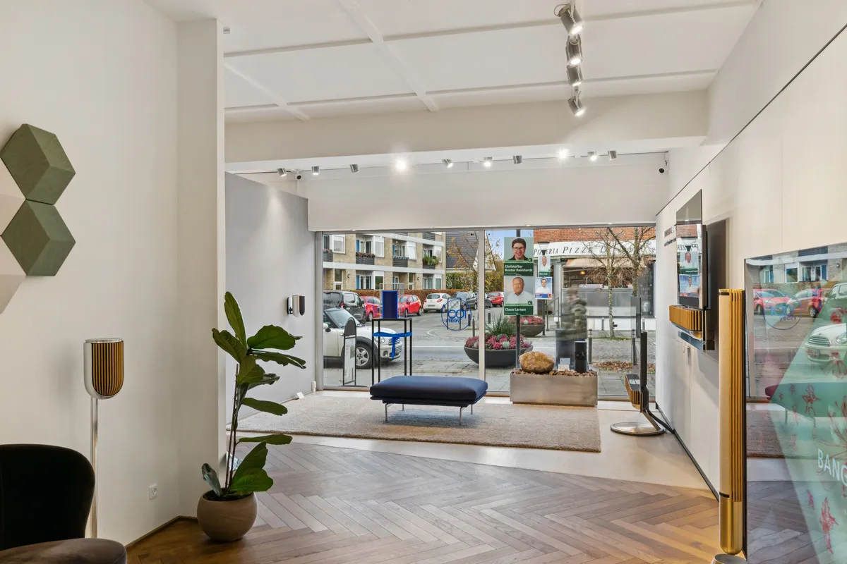 Investeringsmulighed i Vedbæk med moderne interiør, højt beløb, lyse loftslamper og udsigt til gårdhave med plantager og udsigt til gade med biler og bygninger.