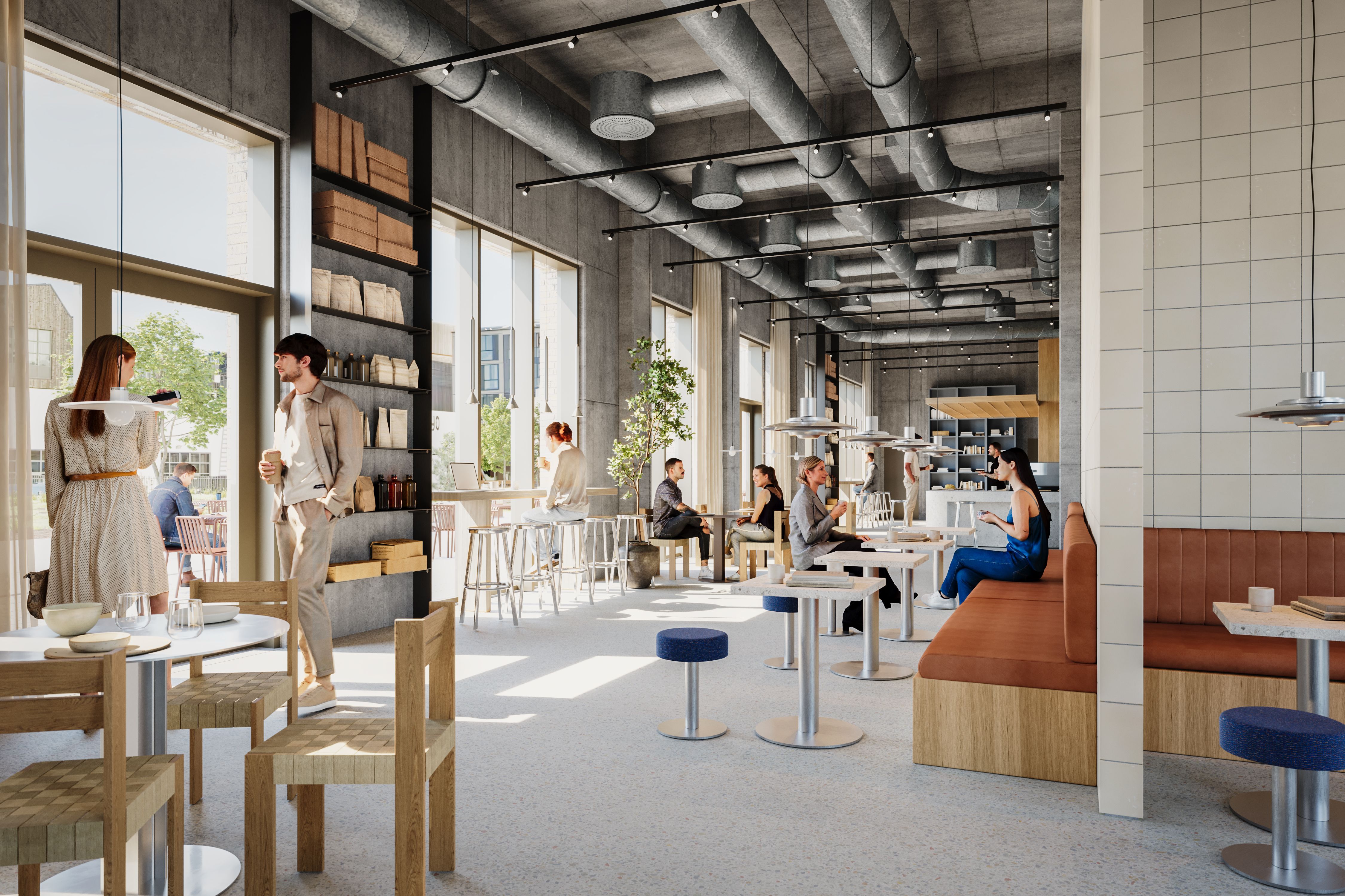 I lyse restaurantlokale med højt loft og store vinduer er folk ved borde og stole og to gæster går ind gennem døren