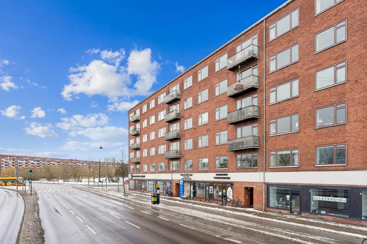 Butik på Åboulevard, st. 3, 1635 København V, med glasvinduer og røde mursten, hvor der er sne på jorden, og vejen er tom