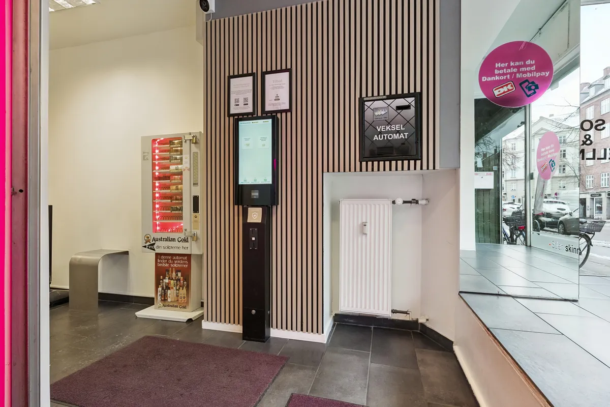 Københavnsk butik med moderne indretning og luksuriøs gulvbelægning. I samme butik er der en billetautomat og en salgsautomat til solcreme.