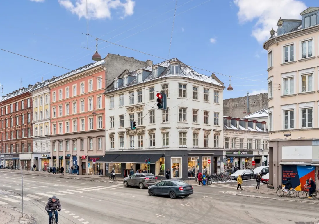 Strømpebilede med cykelriddere og biler på en vejkryds på Østerbro med store bygninger og mennesker