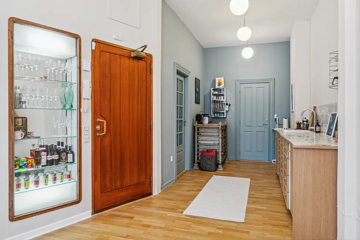 Indehavere kan se en trædør og et skab med glas i en lejlighed med køkken og moderne møbler.