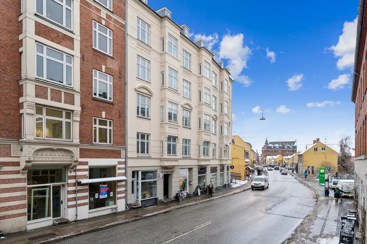 Markant hjørnebutik på Valby Langgade 49B, st., i Valby med høj synlighed og gågade. På hjørnet er en bilparkeringsplads og flere cykler stillet op.