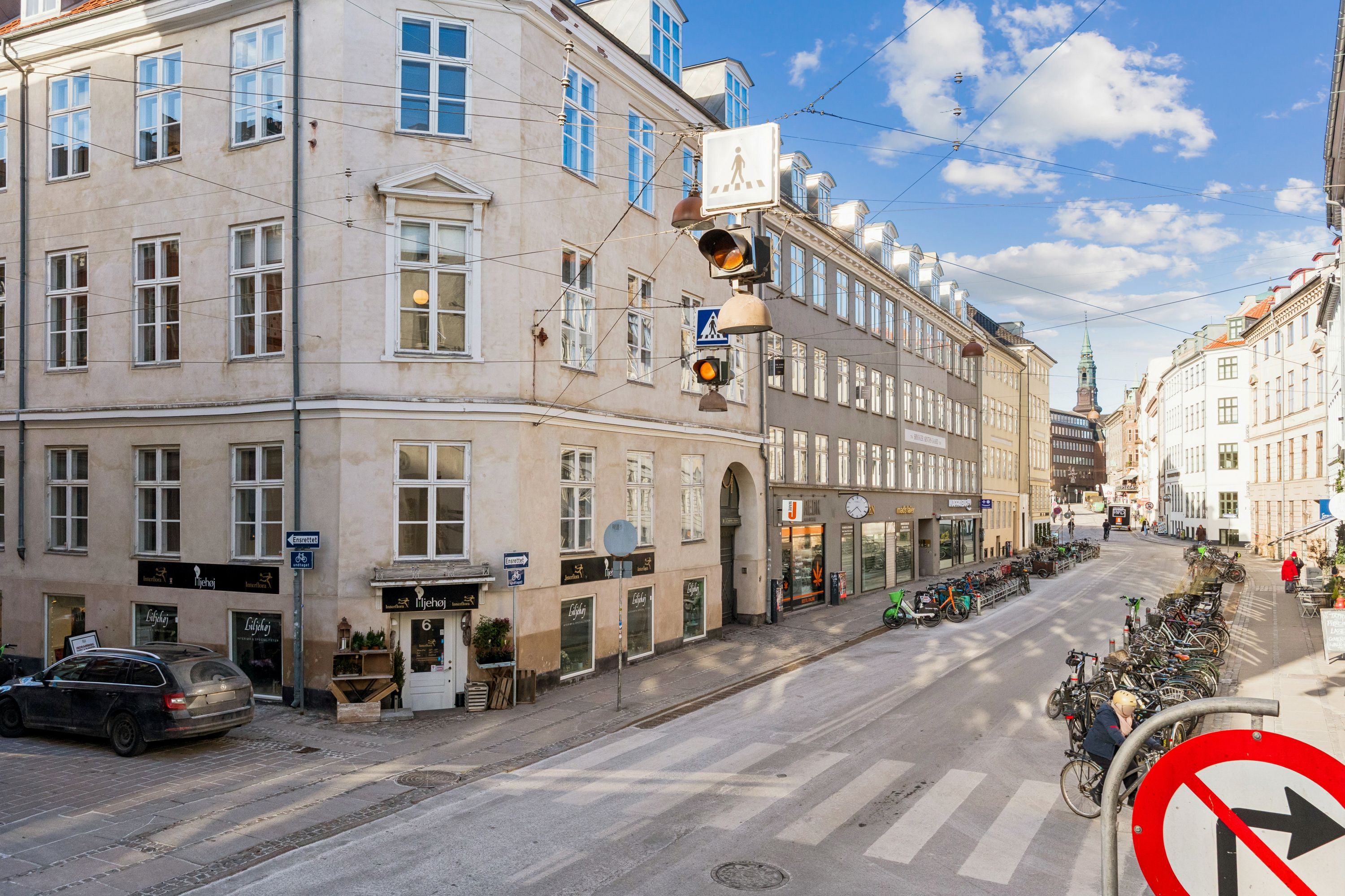 Kontor til leje på Rådhusstræde 6 i København med adgang til Kompagnistræde. Bygning med lyse kontorer og gadeblik mod en tom gade med cykler.