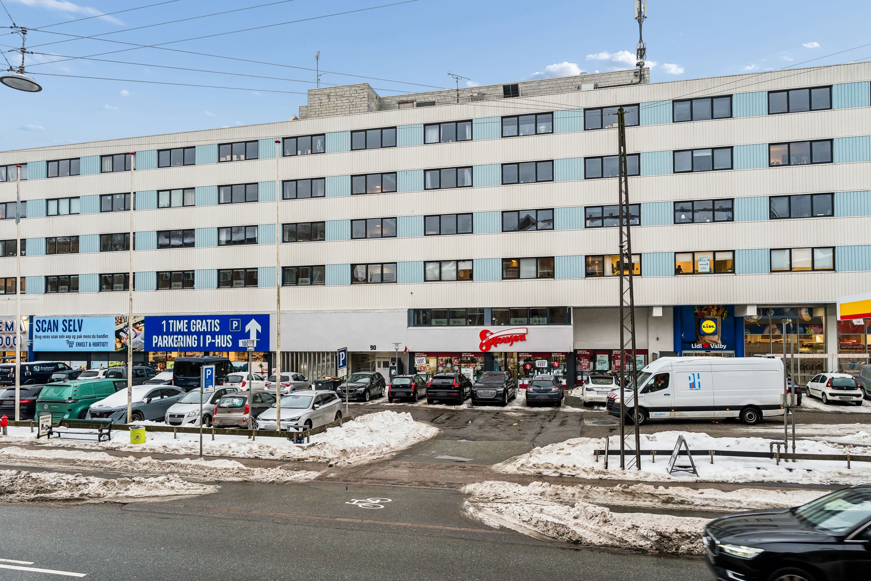 Kontor til salg i Valby med Lidl og Støjfejen parkering og 1 time gratis parkering i P-hus. Sne og biler parkeret foran.