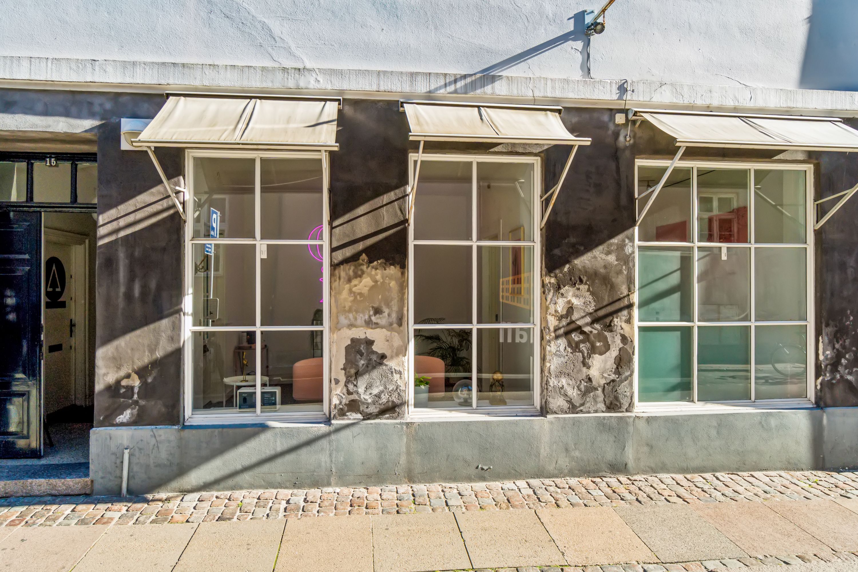 Kontor til leje på Knabrostræde 15 i København K. Lejemål med tre store vinduer og lysegardiner, skrapelister og røde døre.