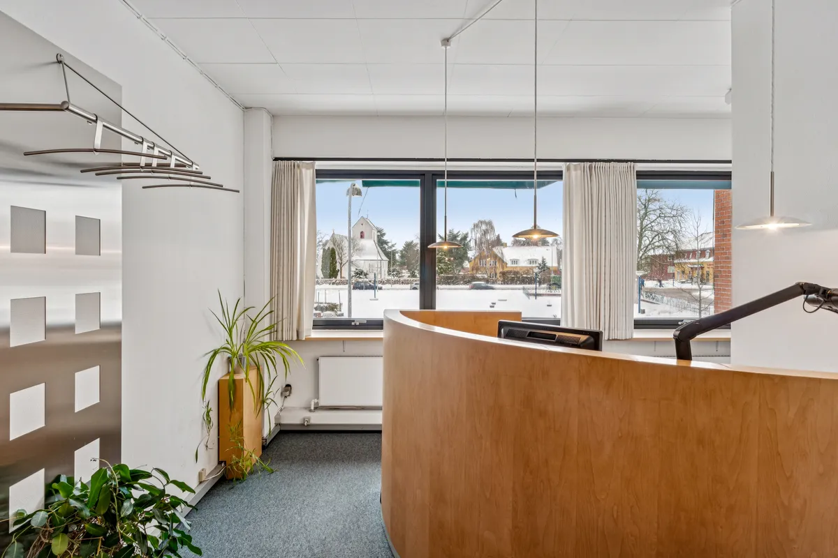 Kontor med udsigt til Hvidovre Torv, hvor der er en slank stolpe med en plante og en udsigt udenfor, hvor der er sne.