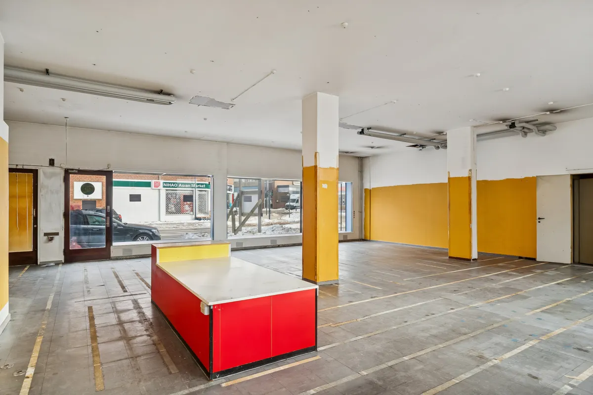 Et glas og cement lokale med en høj loftshøjde og to gulve, gulvet er lige og klar til brug