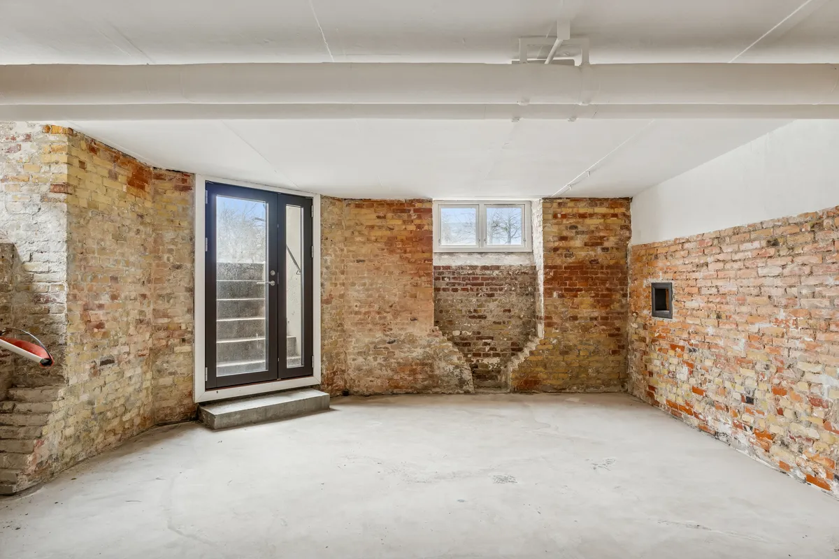 Lager med hjørneegendom og hjørneindgang. Rådighed med glasdøre og vinduer. Murene er lavet af mursten og der er hvid gulvbelægning.