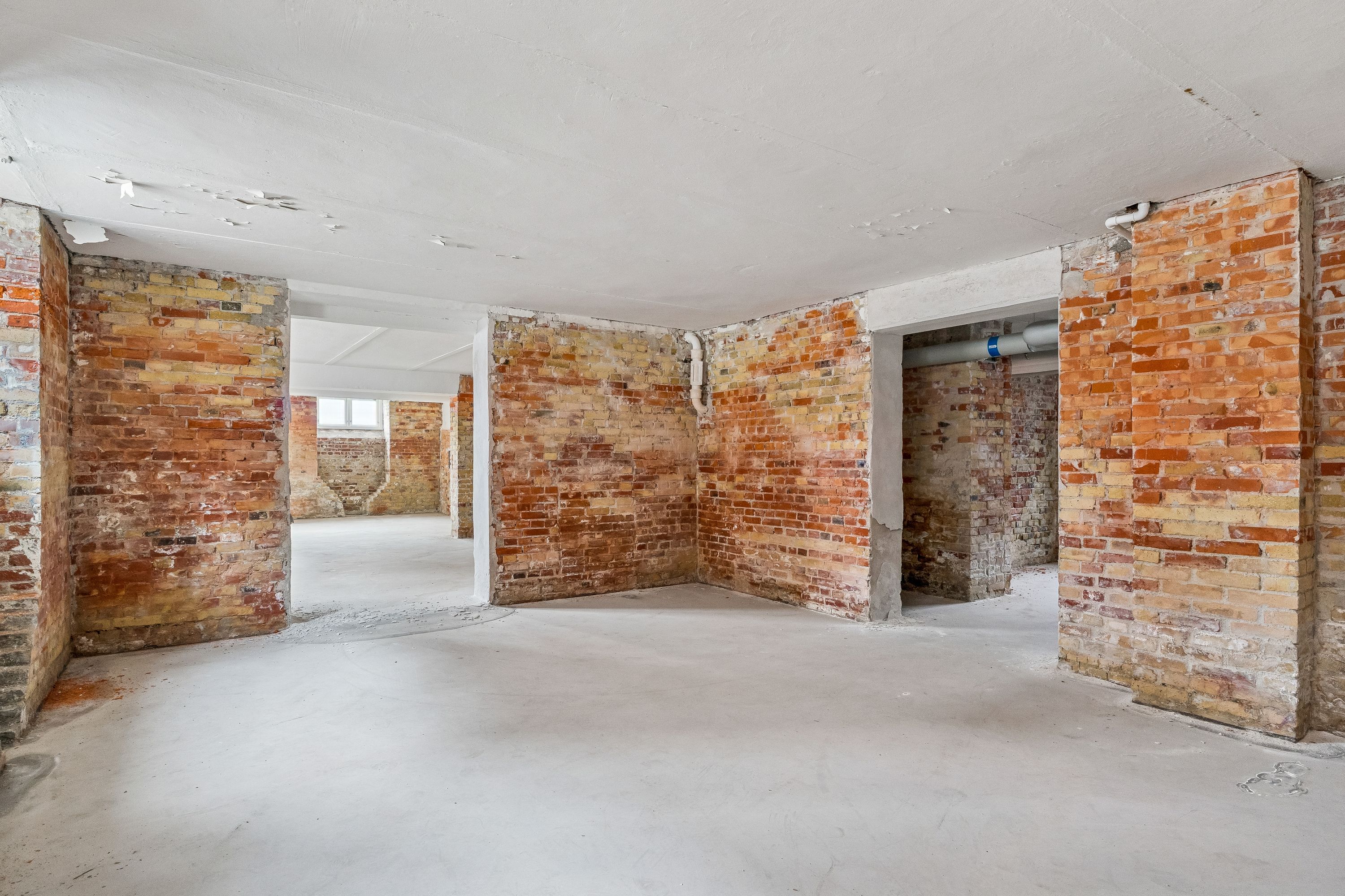 Lager til leje på Islands Brygge 19 i København S. Bygningen er renoveret og har røde murstensvægge og ny cementgulv.