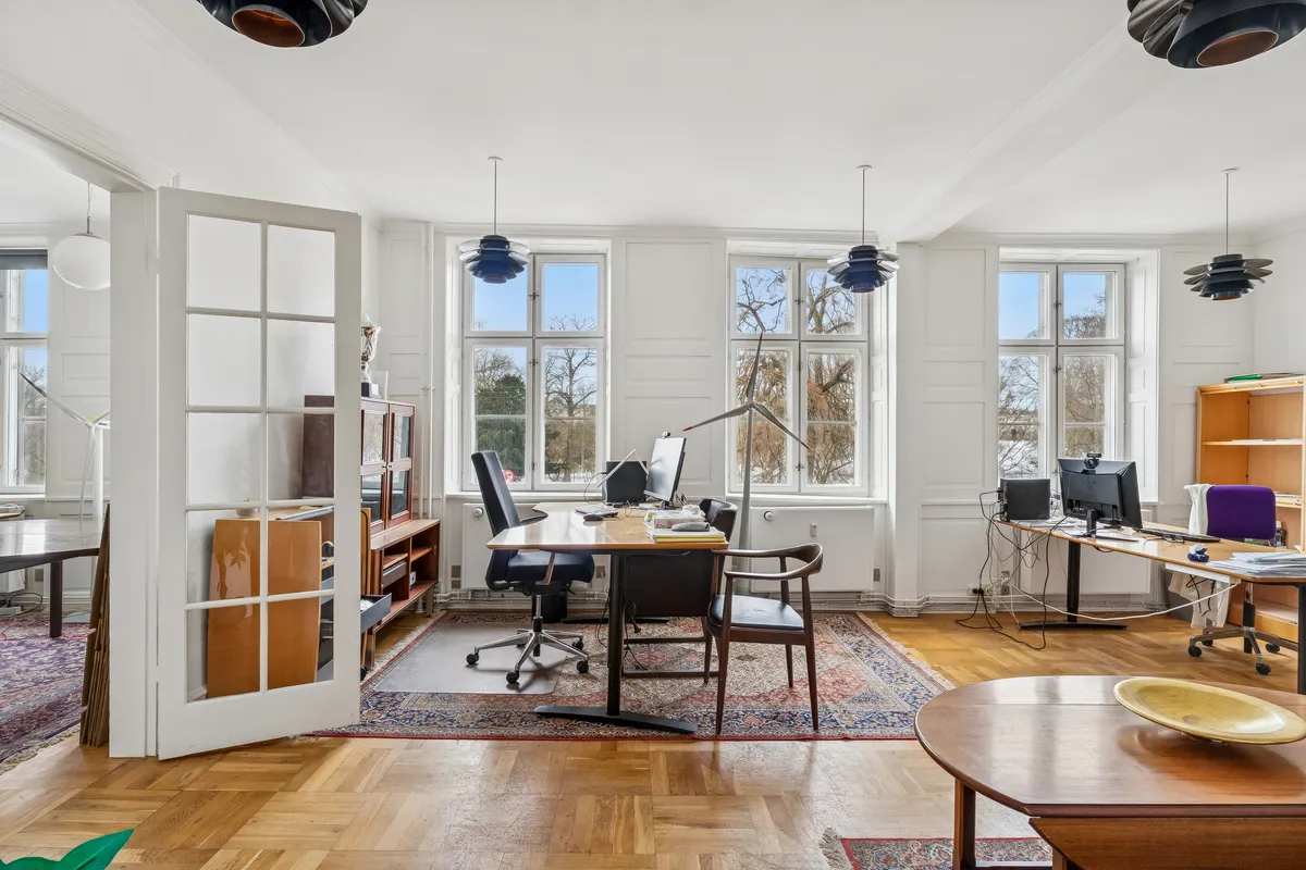 Lejlighed med to skriveborde, stole, skærme, lamper og bibliotek i forretningslokale på Nørre Voldgade i København