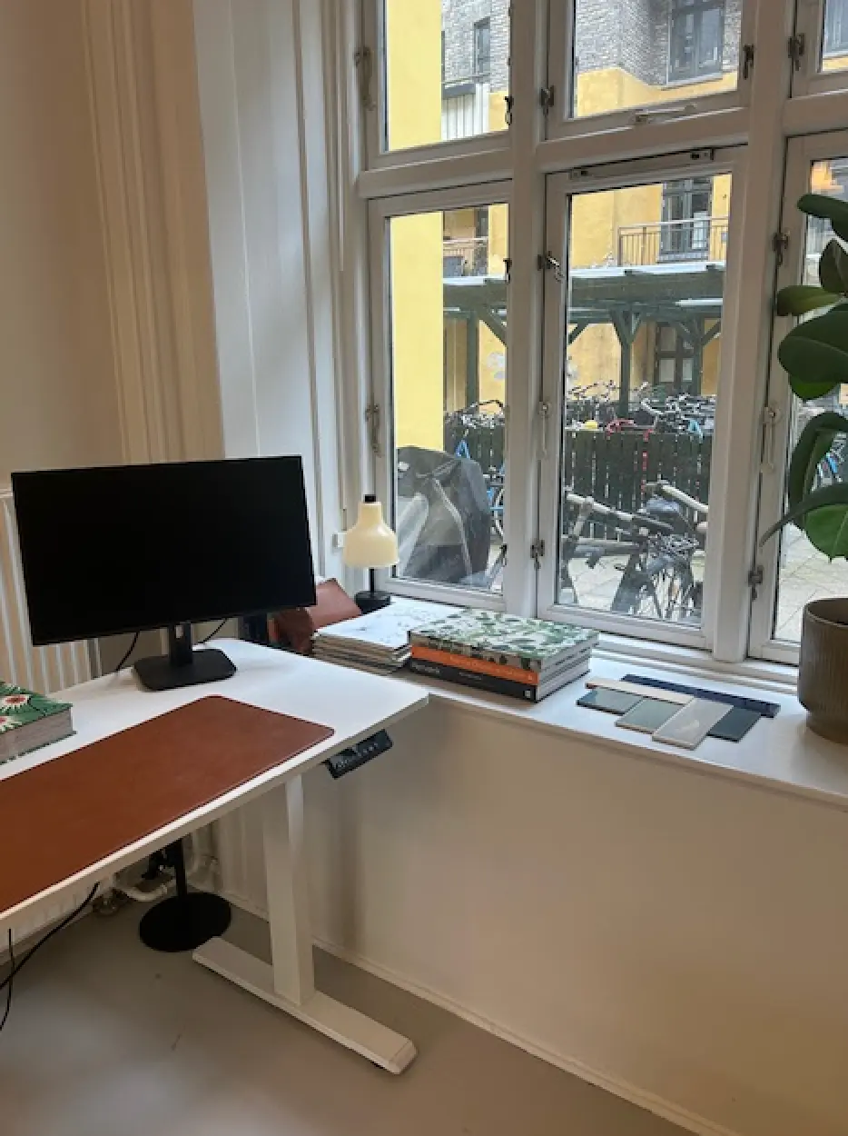 Køkkenbord med monitor, lampe og flere bøger og skabeloner til design og branding.