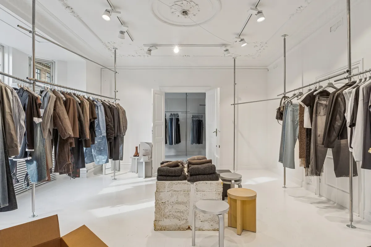 Kontor til leje i Frederiksberg med store vinduer og lys indretning, møbler og tøj i showroomet