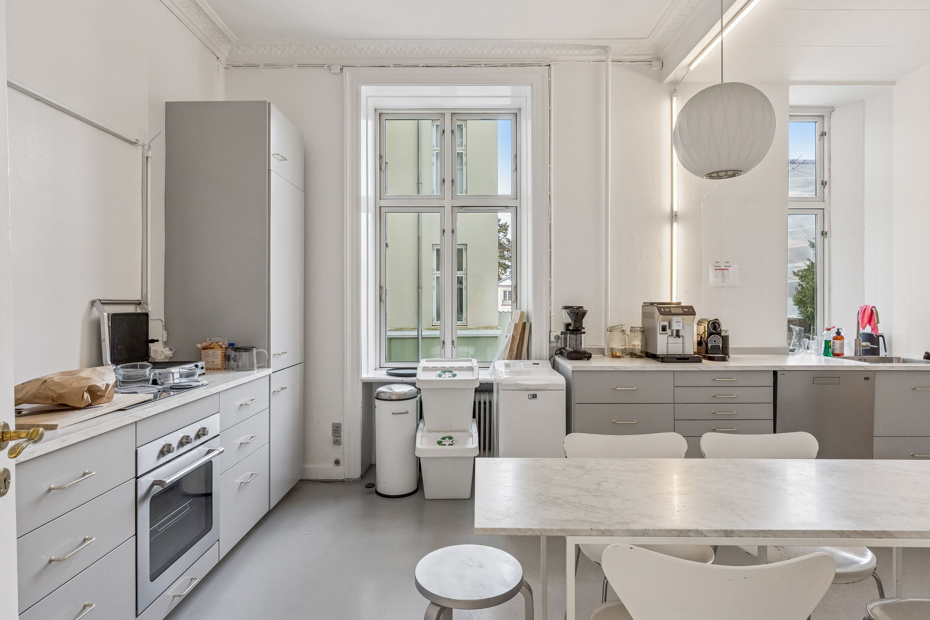 Kontor til leje på Gammel Kongevej 102, 1. tv, 1850 Frederiksberg C. Rummelig køkken med hvide skabe, trægulv, moderne apparater og stort vinduesfelt