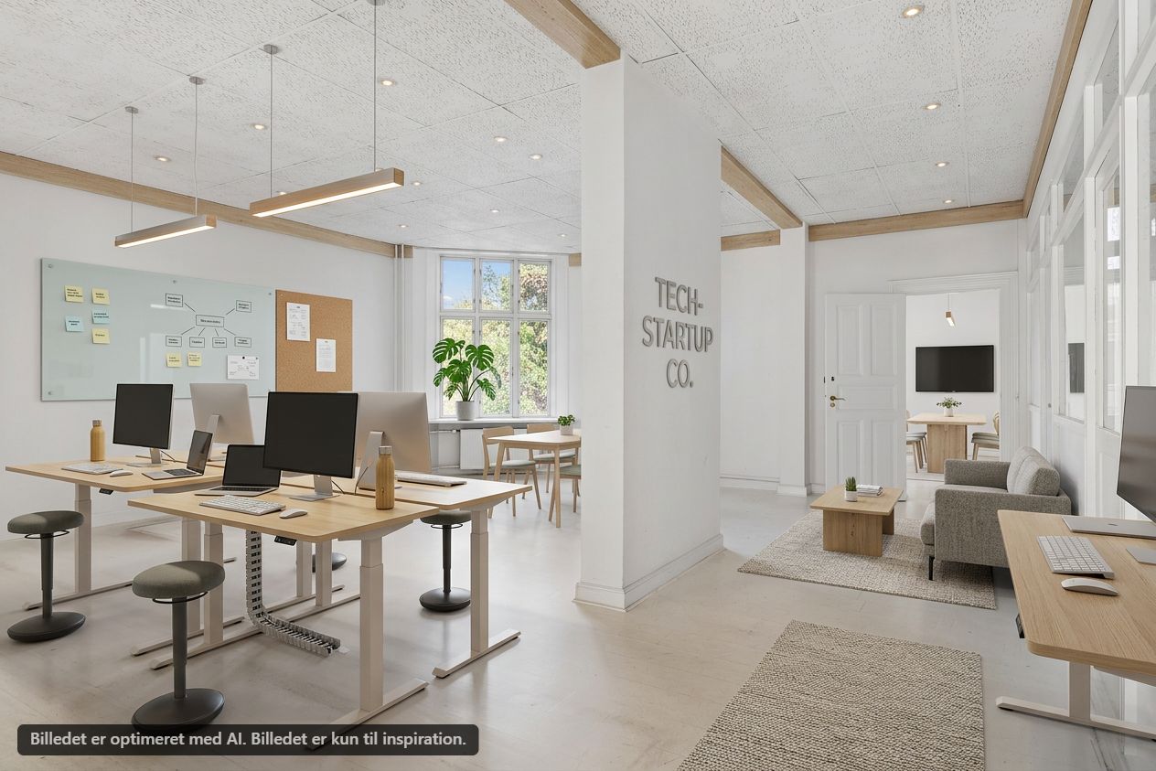 Kontor med lyse loftslamper, lyse vægge, skriveborde, stolpe og tekst "Tech-Startup Co." på væggen. Bord med monitorer, laptops og mus samt en sofa med et bord og en plante