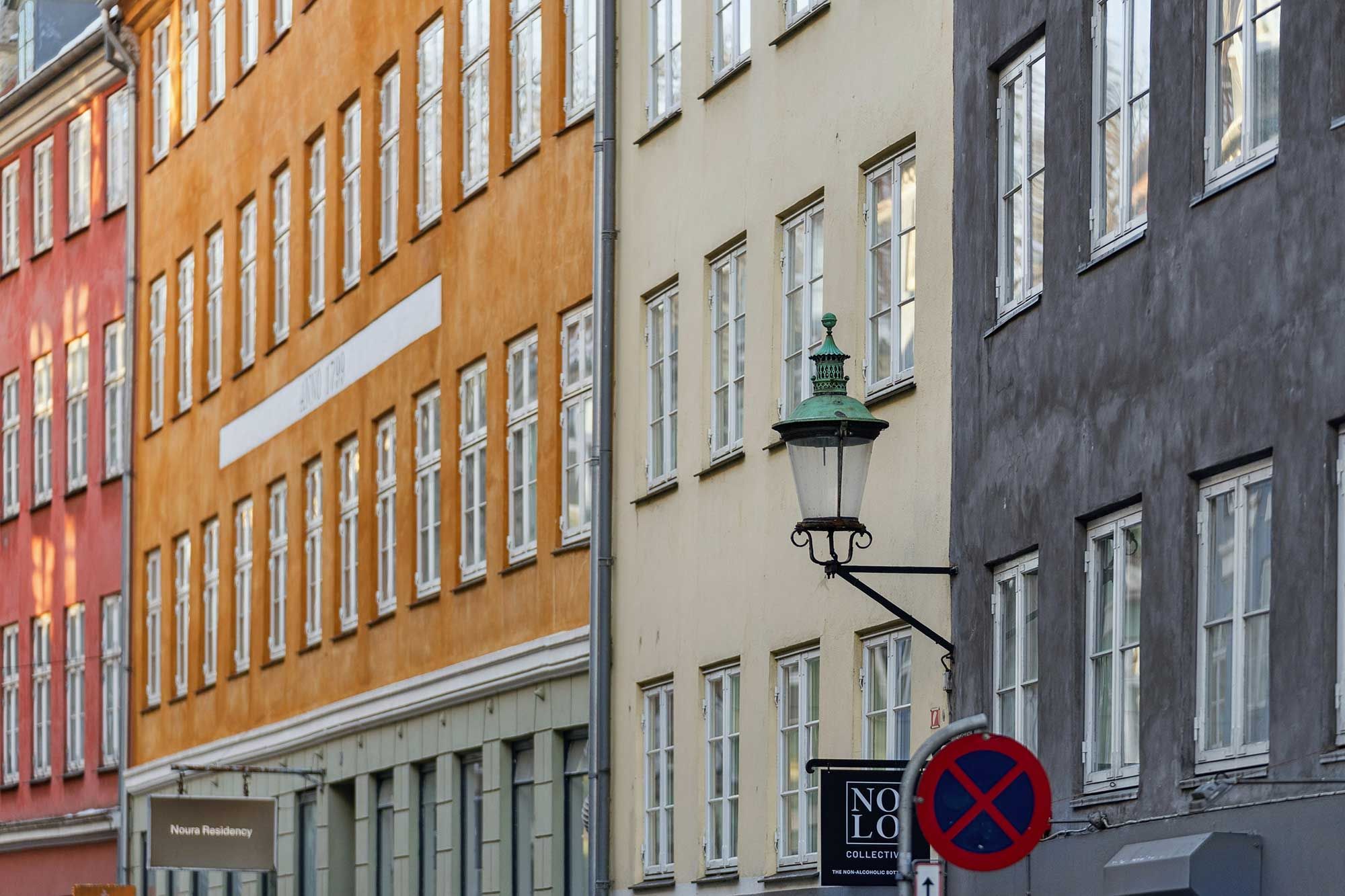 Kontorlejemål i Latinerkvarter med mange vinduer og en lampe. De tre bygninger er fredet og har lyserøde, gule og grå facader.