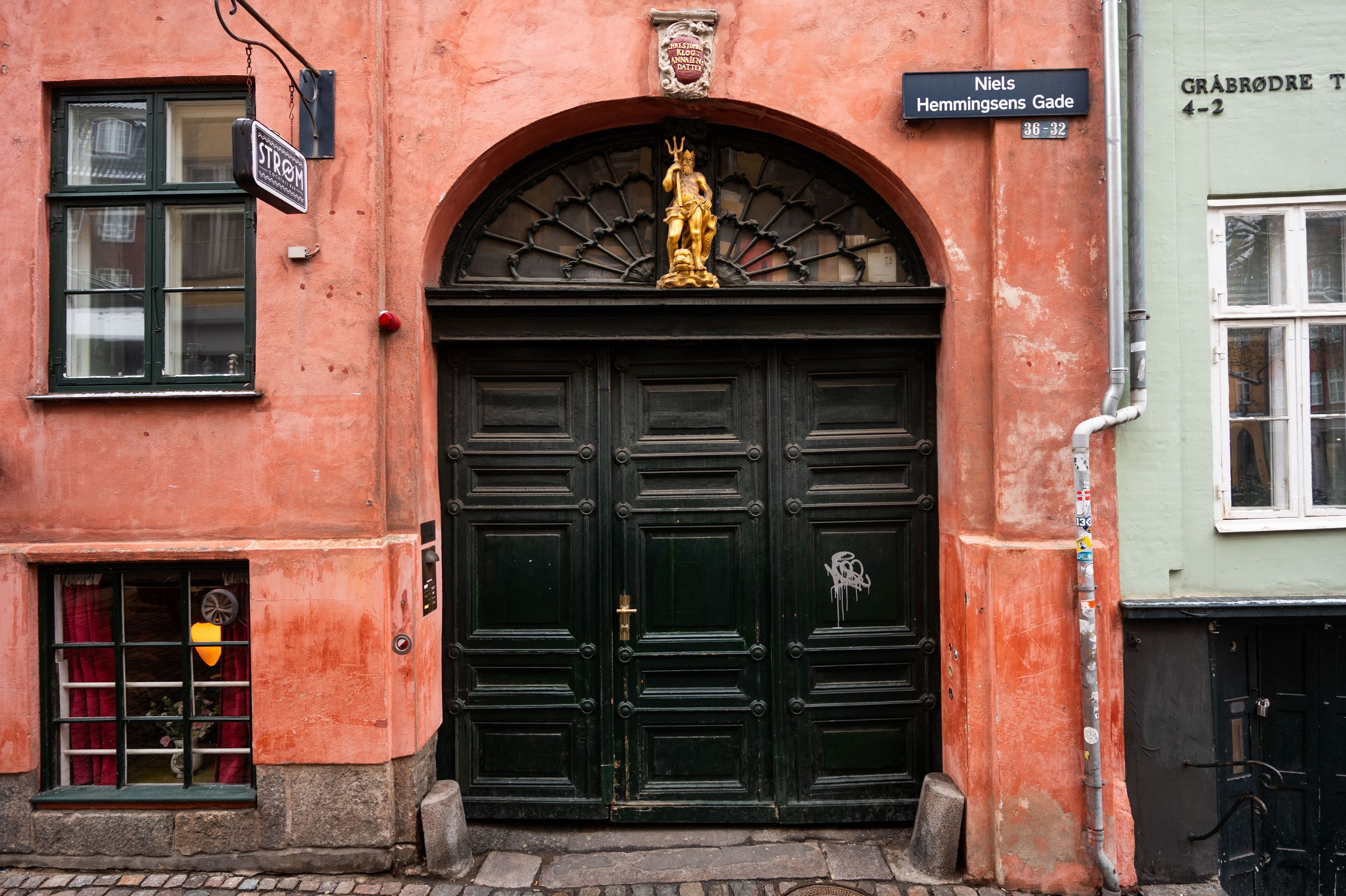 Kælderlejlighed på Niels Hemmingsens Gade i København med skulptur af Neptunus over indgangsdøren og et særligt udseende gulv og vægge
