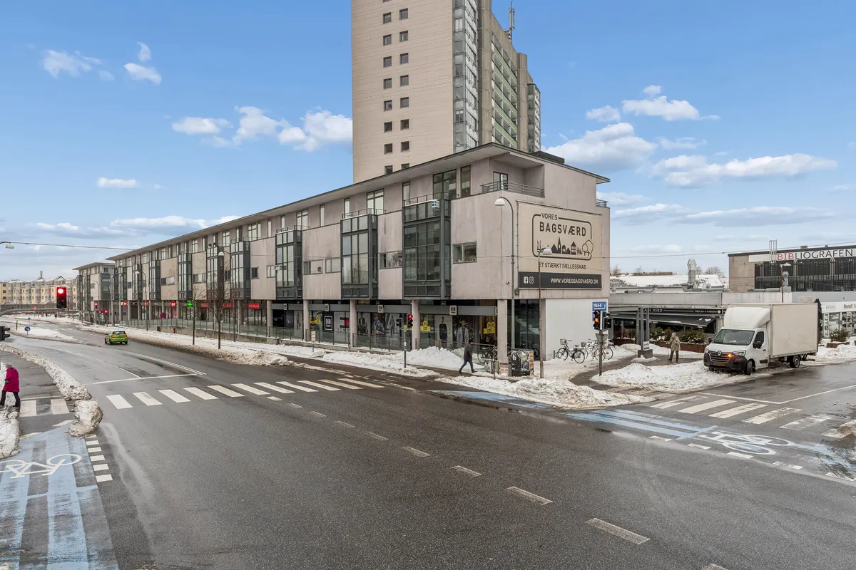 Butik til leje på Bagsværd Hovedgade 126 st. B+C, 2880 Bagsværd. Butik med udsigt til gågade og foran højhus. Snedækket område med gåstrimmel og cykelsti.