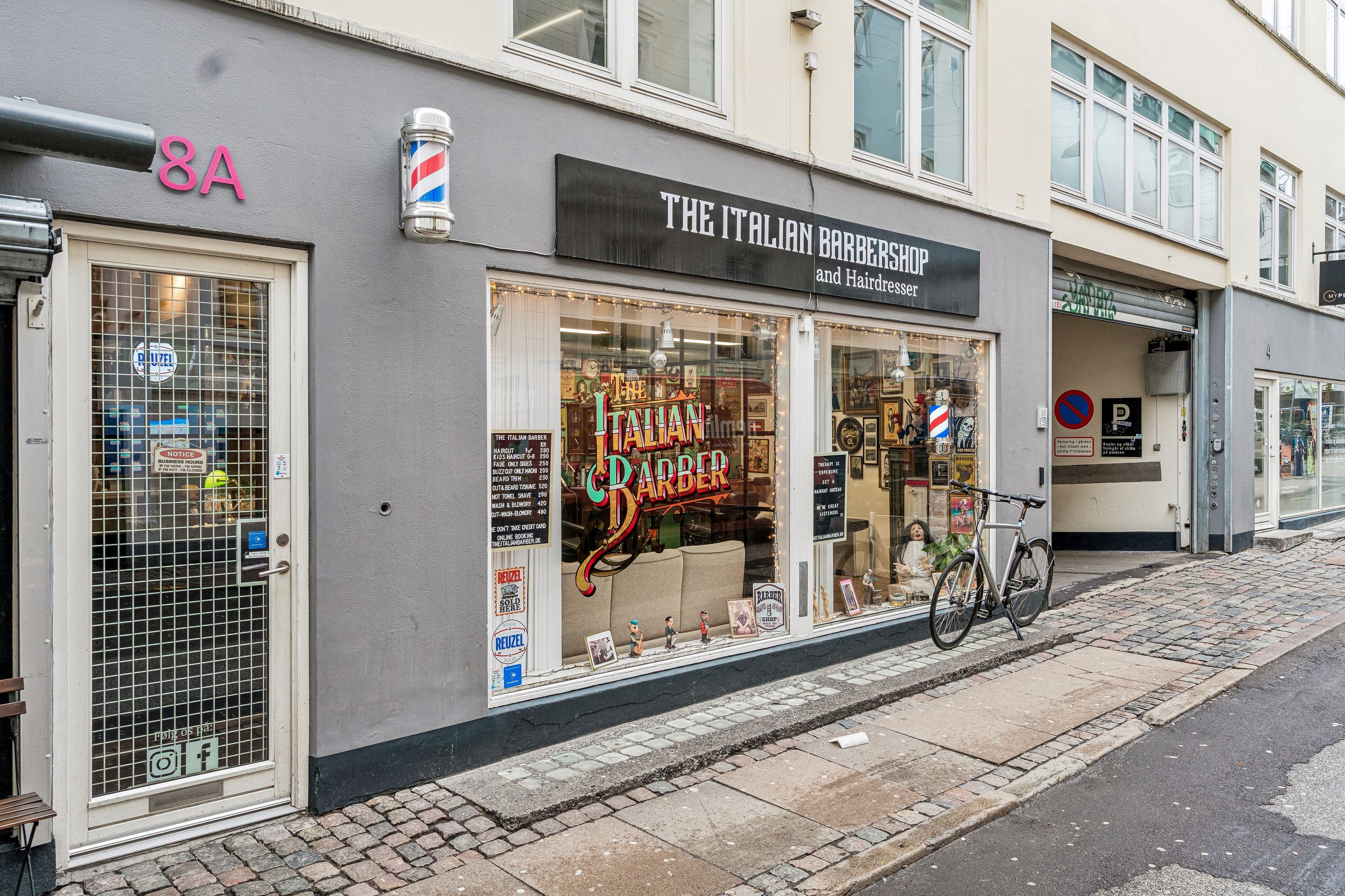 Butik til leje på Knabrostræde 8A i København K. The Italian Barbershop og frisørforretning med barberstav og skilt. Cykel parkeret foran butikken.