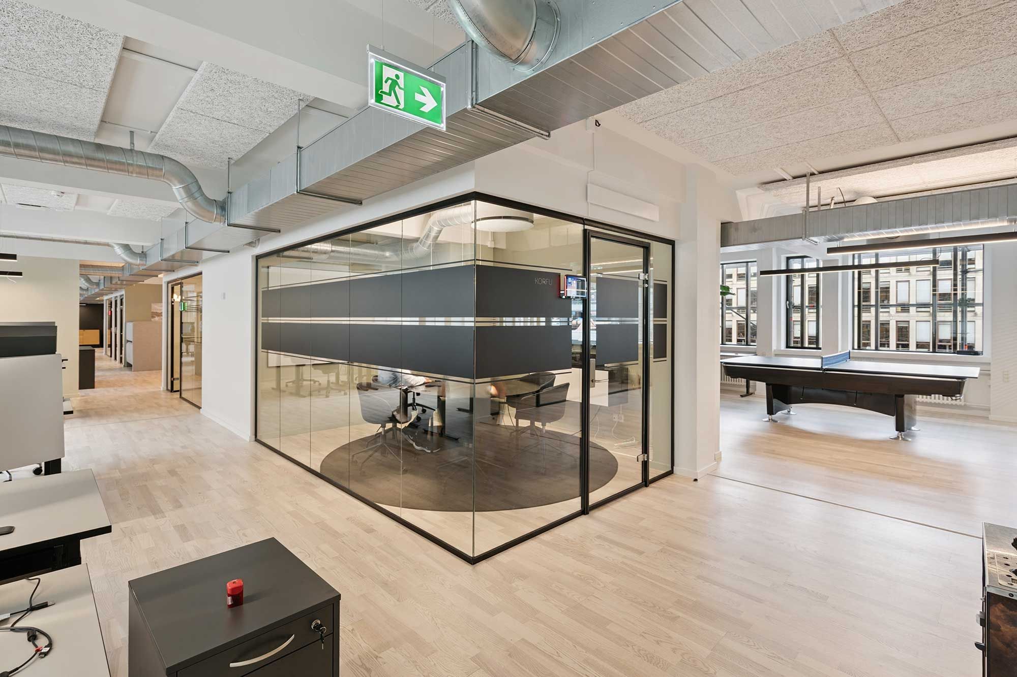 Glas og træ kombineret til moderne kontor med høj gulv og udsigter til byen med pingpongbord og skov og vinduer