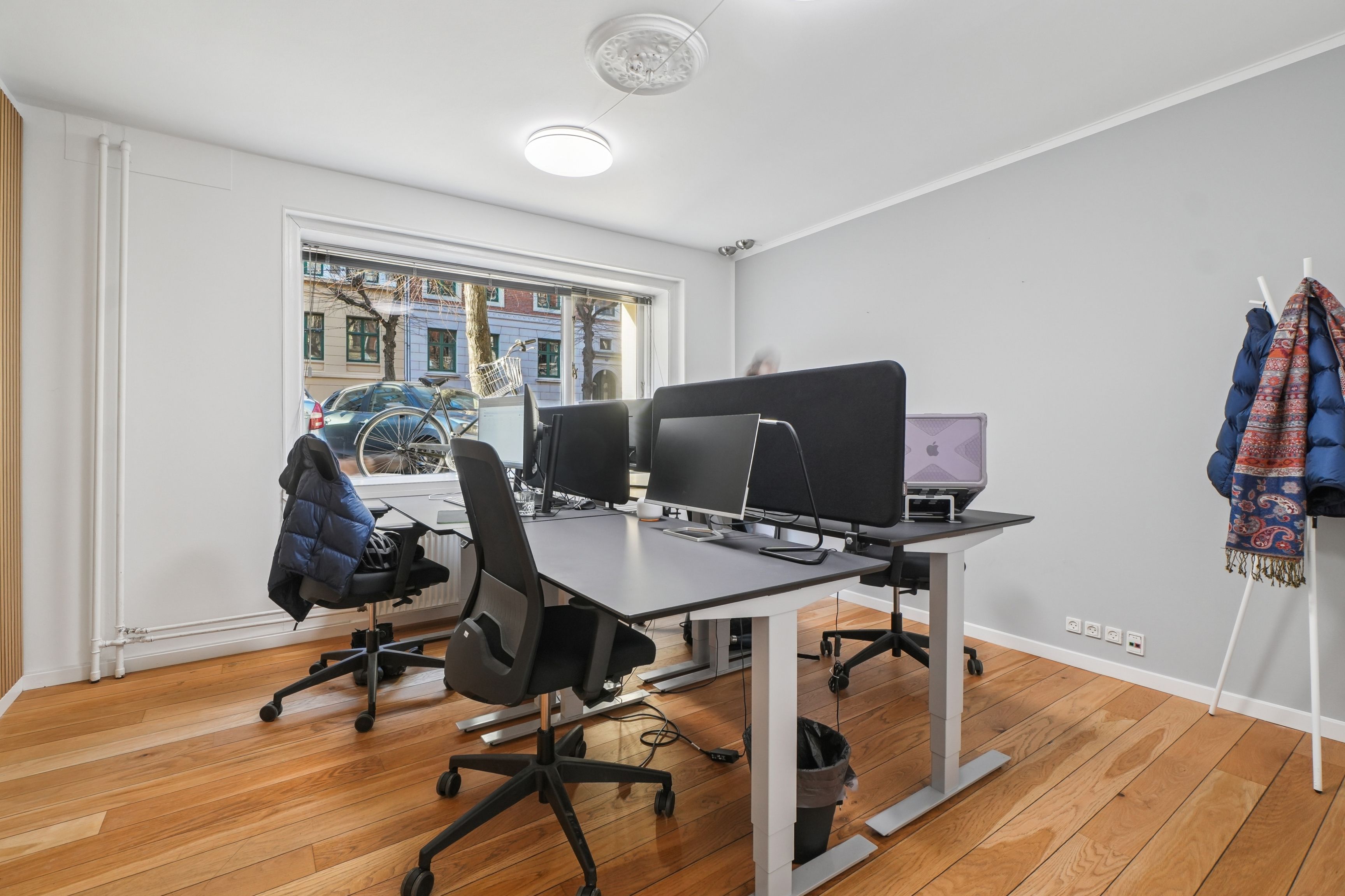 Kontorrum med moderne skriveborde og højkvalitets møbler, fuldt udstyret med computere og lyse gulvbelægning