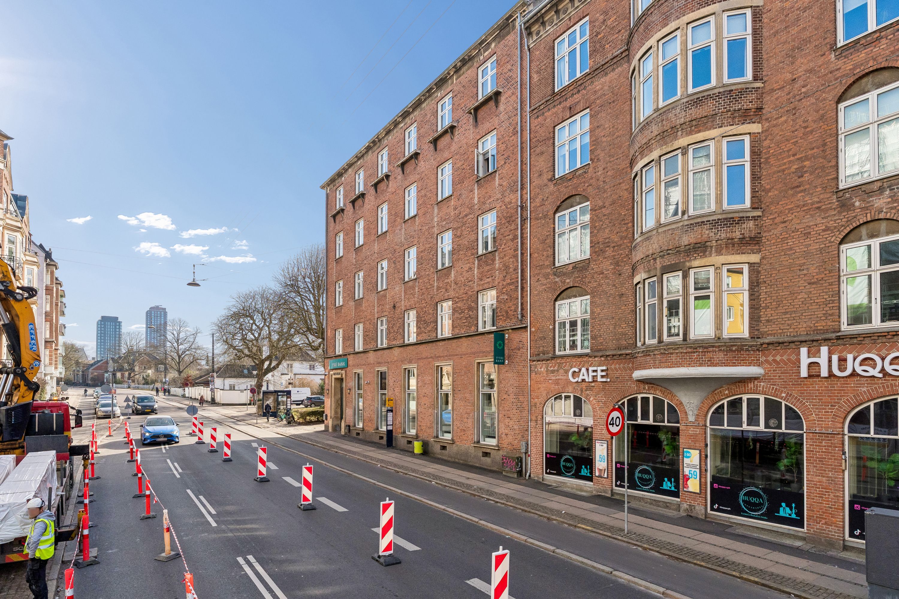 Kontor til leje i rødstenebygning i Valby. Lejemål med cafe, 40 km/t adgangsvej og trafikkegler i vejen.